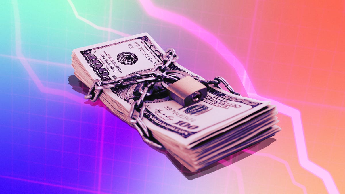 A pile of cash with a padlock wrapped around it