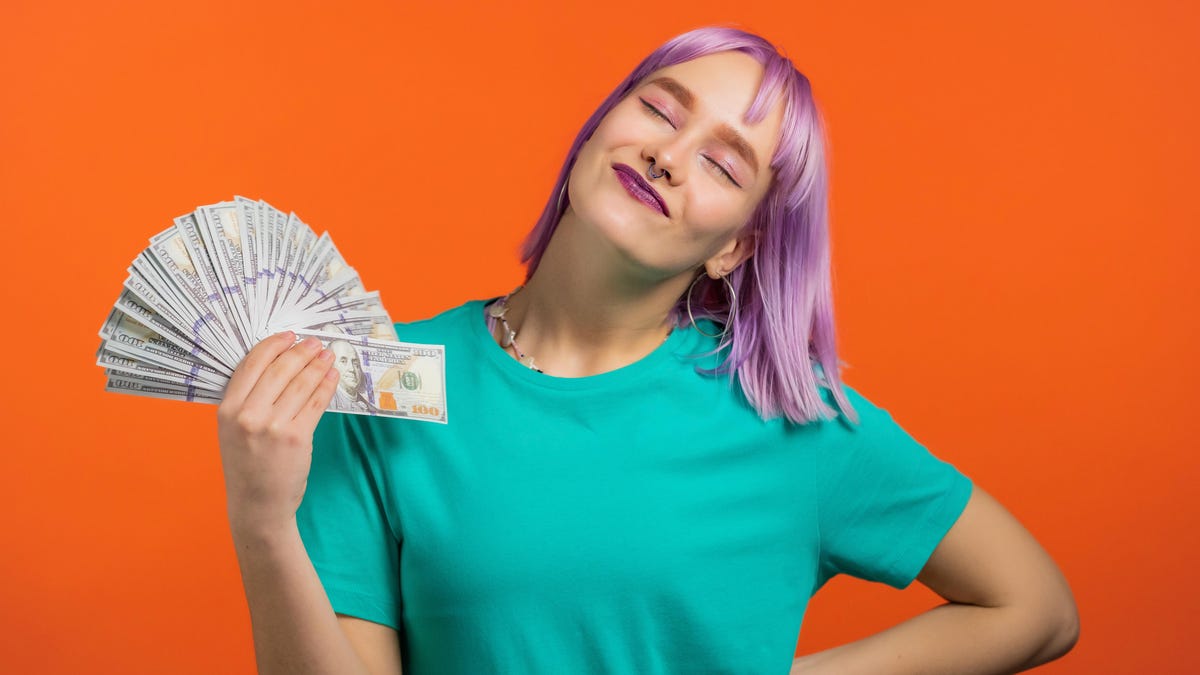 girl with pink hair fanning money